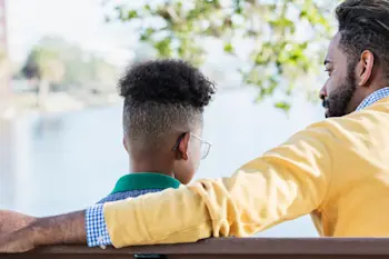 Father and son sitting together talking
