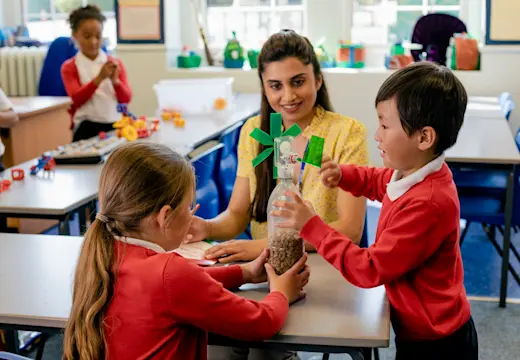 Children in primary school playing with a teacher