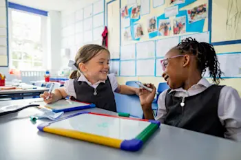 2 girls colouring together in school