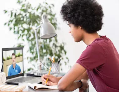 Boy sitting down to do his GCSE online tuition session with an Explore Learning online tutor.