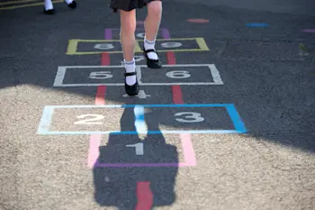 Child playing hopskotch in the playground