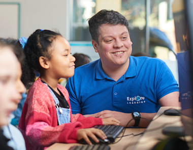 Photo of an Explore Learning tutor helping a child with Member Portal