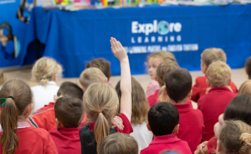 A group of children sitting in a school assembly hosted by Explore Learning